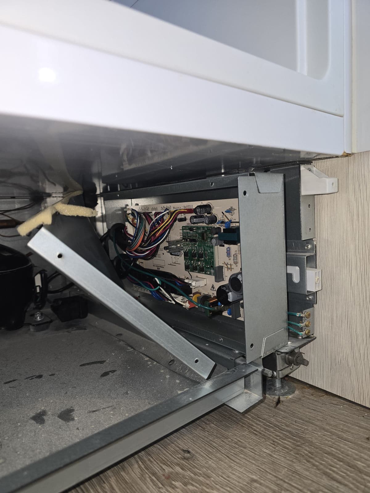 Refrigerator control board being repaired in a kitchen